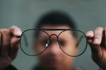 man holding eyeglasses